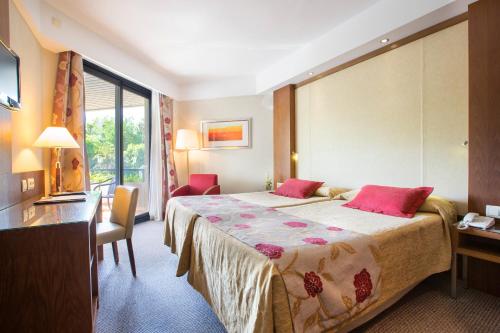 a hotel room with a bed and a desk at Hipotels Sherry Park in Jerez de la Frontera