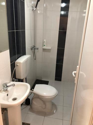 a bathroom with a toilet and a sink at Hotel Living in Šuto Orizari
