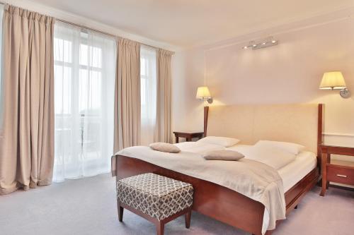 sypialnia z dużym łóżkiem i biurkiem w obiekcie Sun Palace Wellness Hotel w Mariańskich Łaźniach