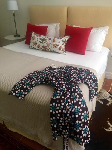 a bed with a black flowered blanket on it at Southey House in Kloof
