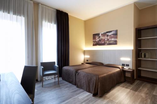 ミラノにあるホテル リッテルのベッドと椅子付きのホテルルーム