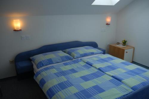 a bedroom with a blue bed with two pillows at Guest Accomodation Škerlak in Moravske Toplice