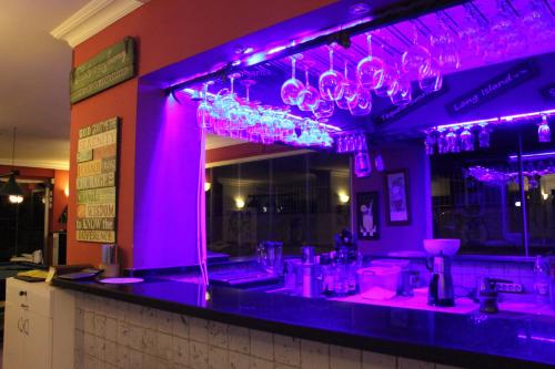 a bar with purple lighting in a restaurant at Belle Ocean Apart Otel in Alanya