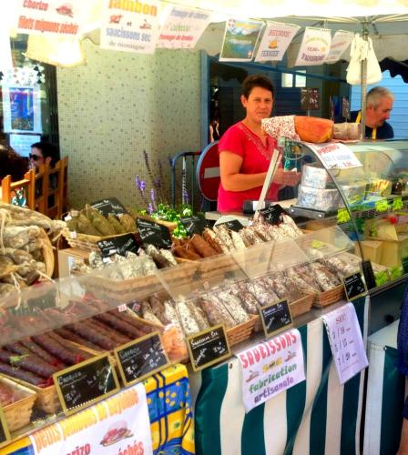 une femme debout derrière un comptoir dans un marché avec de la nourriture dans l'établissement PRIVATE POOL with Stunning Views of the Chateau!! Old Barn, à Rouffignac-Saint-Cernin-de-Reilhac