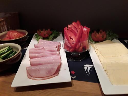 a table with two plates of meat and a cake at Kumlinge Stugor in Kumlinge