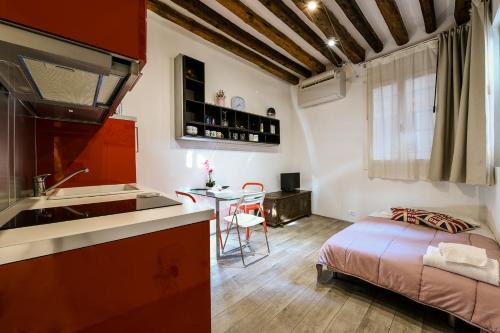 una cocina y un dormitorio con una cama en una habitación en La Perla, en Venecia