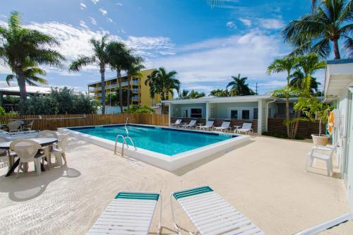 a pool with chairs and a table and a house at Harborside Motel & Marina in Key West
