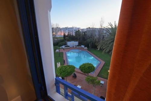 una ventana con vistas a la piscina en Senator Hotel Tanger en Gzennaïa