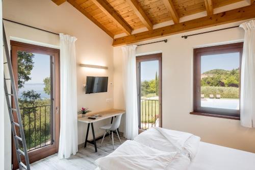 a bedroom with a bed and a desk and windows at Agriturismo Ca' Zerbetto in Bardolino
