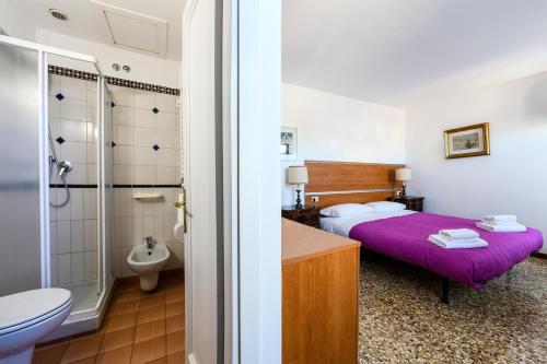 uma casa de banho com uma cama, um WC e um lavatório. em Rialto Apartment em Veneza