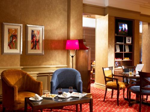 a waiting room with chairs and tables and a lamp at Grand Hotel Gosforth Park in Newcastle upon Tyne