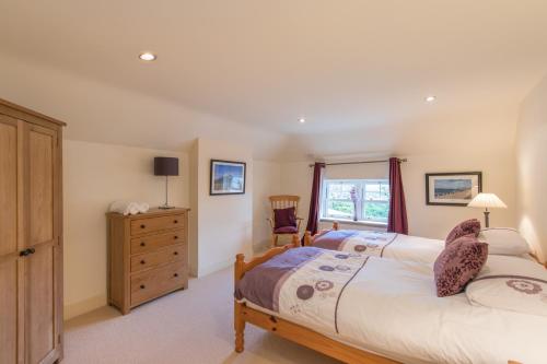 a bedroom with two beds and a dresser and a window at The Nook County Dublin in Dublin