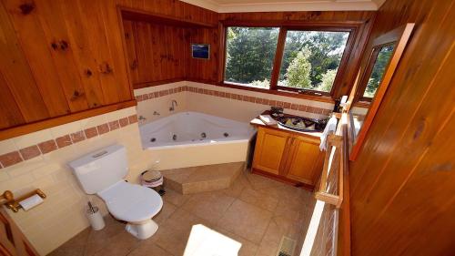 a bathroom with a tub and a toilet and a sink at Santosha Glade near the Everglades in Leura
