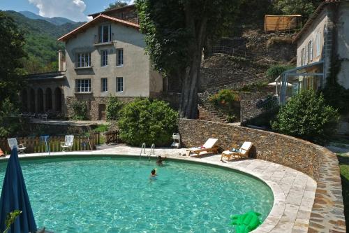 une personne se baignant dans une piscine en face d'une maison dans l'établissement Le Clarou, à Valleraugue