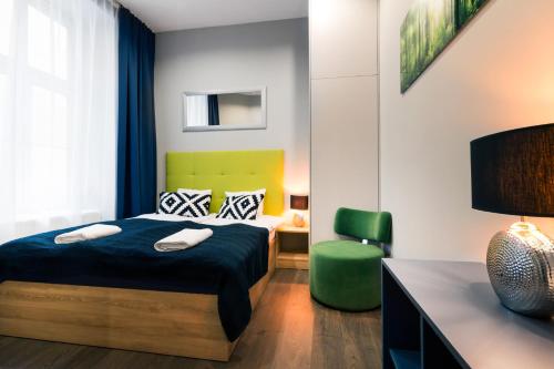 a bedroom with a bed and a desk and a chair at Kings City - Sławkowska Apartments in Krakow