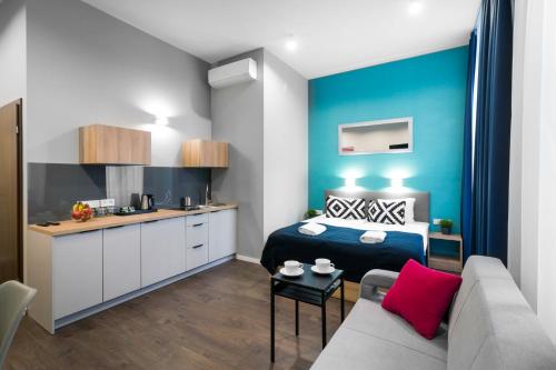 a small room with a bed and a kitchen at Kings City - Sławkowska Apartments in Krakow
