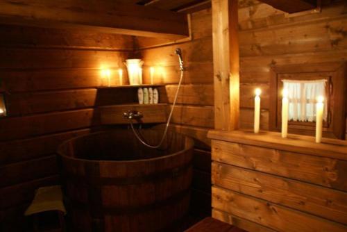 a wooden bathroom with a tub with candles in it at Modrá chalúpka in Kremnica