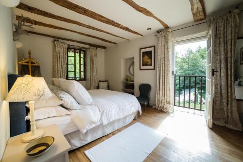 a bedroom with a bed and a large window at Moulin de Latreille in Calès