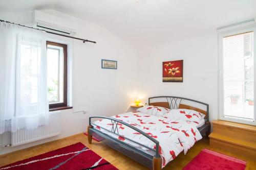 a bedroom with a bed with white walls and windows at Charming Apartment in Koper