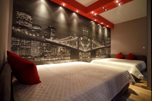 two beds in a bedroom with a wall mural of a city at Apartamenty Dream of Bydgoszcz in Bydgoszcz