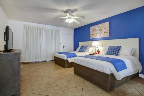 a bedroom with two beds and a blue wall at Blue Strawberry by the Sea in Fort Lauderdale
