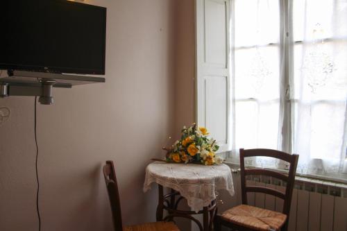 una mesa con un arreglo floral junto a una ventana en La Locanda Del Podestà Cinque terre, en La Spezia