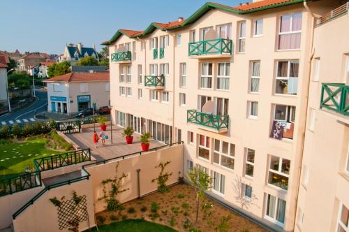 un immeuble d'appartements avec balcon sur le côté. dans l'établissement Résidence Pierre & Vacances Premium Haguna, à Biarritz