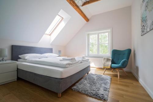 a bedroom with a bed and a blue chair at Ostoja in Rzyki