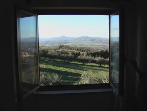 a window with a view of a field and mountains at Deliziosa Villa Panoramica in Campagnano di Roma
