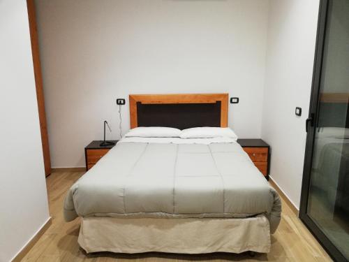 sypialnia z dużym łóżkiem z białą pościelą w obiekcie B&B Controtempo w mieście Reggio di Calabria
