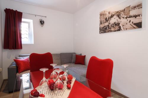 a living room with a table and red chairs at Split Inn Apartments in Split