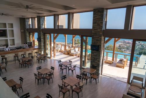 a restaurant with tables and chairs and a view of the ocean at Satama Hotel in Cap-Haïtien