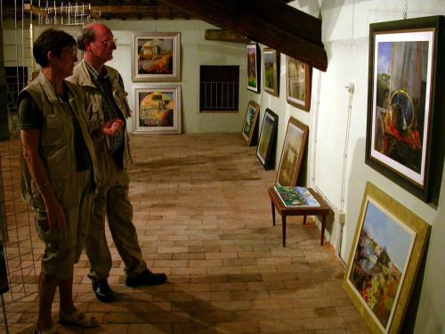two men standing in a museum looking at paintings at Bordeghina B&B In Farmhouse in Pontecchio Polesine