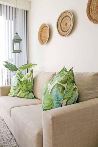 a living room with a couch with two pillows on it at Infinity LG8 Beachfront Apartment in Bloubergstrand