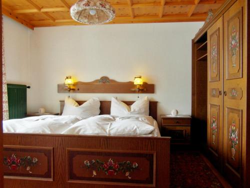 1 dormitorio con 1 cama grande con sábanas blancas en Pension Stüttler, en Schruns