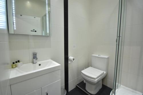 La salle de bains blanche est pourvue de toilettes et d'un lavabo. dans l'établissement Apt 2, Soho Apartments 1st floor by Indigo Flats, à Londres