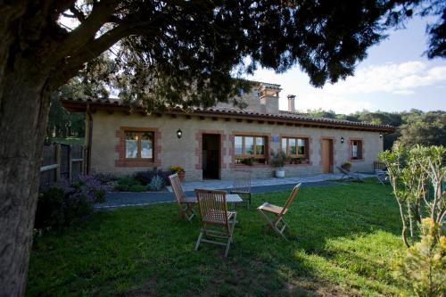 a house with chairs and a table in the yard at Mas Pratsevall in Taradell