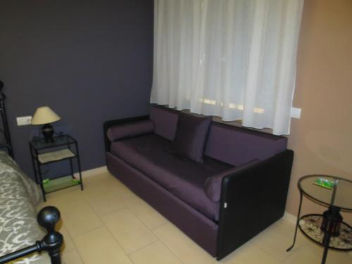 a purple couch in a living room with a window at Artisti Rooms in Ravenna