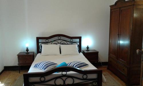 a bedroom with a bed with two pillows and two night stands at Patio das Flores in Ferreira do Alentejo