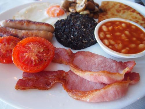 Un plato de comida para el desayuno con tocino, tocino, frijoles y frijoles. en Park Hotel, en Thurso