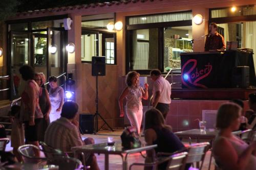 a woman is standing on a stage in a restaurant at Hotel Univers in Roses