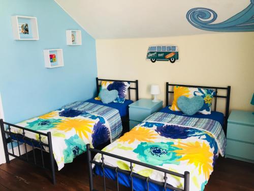 two beds in a room with blue walls at The Paintshop Hostel in Figueira da Foz