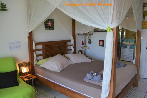 a bedroom with a bed with a canopy at Frangipani Studio Réunion in La Saline les Bains