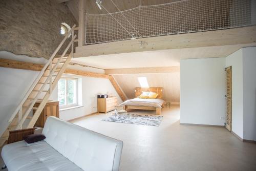 ein Wohnzimmer mit einer weißen Couch und einer Treppe in der Unterkunft La Joux Chaupe in Saint-Ursanne