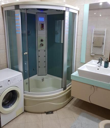 un bagno con doccia e lavatrice di Luxe Apartment a Ohrid