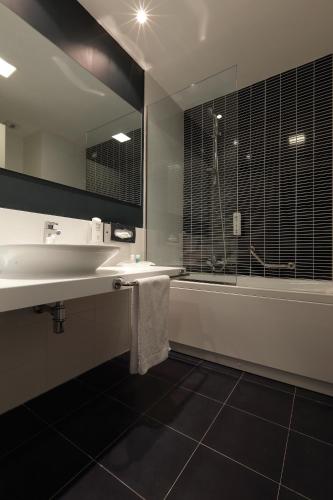 a bathroom with a sink and a shower and a mirror at Holiday Inn Milan Nord Zara by IHG in Cinisello Balsamo