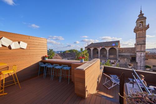 a balcony with a bar with a view of a church at Santa Clara Urban Hotel & Spa in Palma de Mallorca