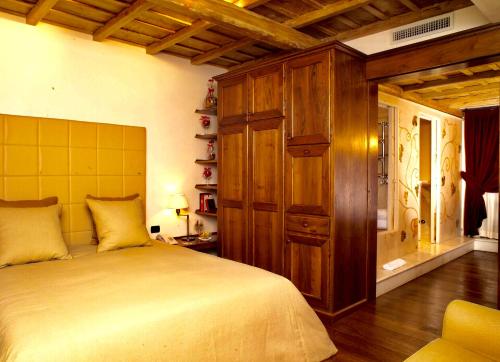 a bedroom with a large bed and a wooden cabinet at Locanda dello Spuntino in Grottaferrata