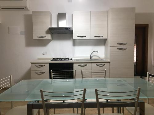 a kitchen with a glass table and some chairs at Juliet's House in Lettomanoppello