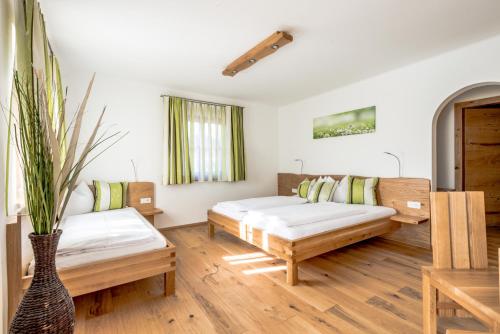 salon z dwoma łóżkami i kanapą w obiekcie Pension Tannhof w mieście Fuschl am See